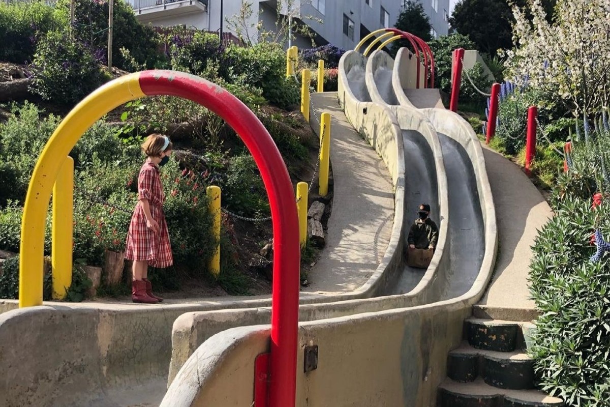 Kids play on large concrete slides.