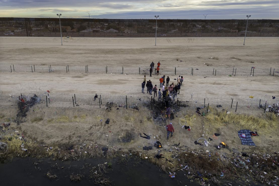 Migrants pass through razor wire after crossing the Rio Grande into El Paso, Texas, on February 1, 2024.