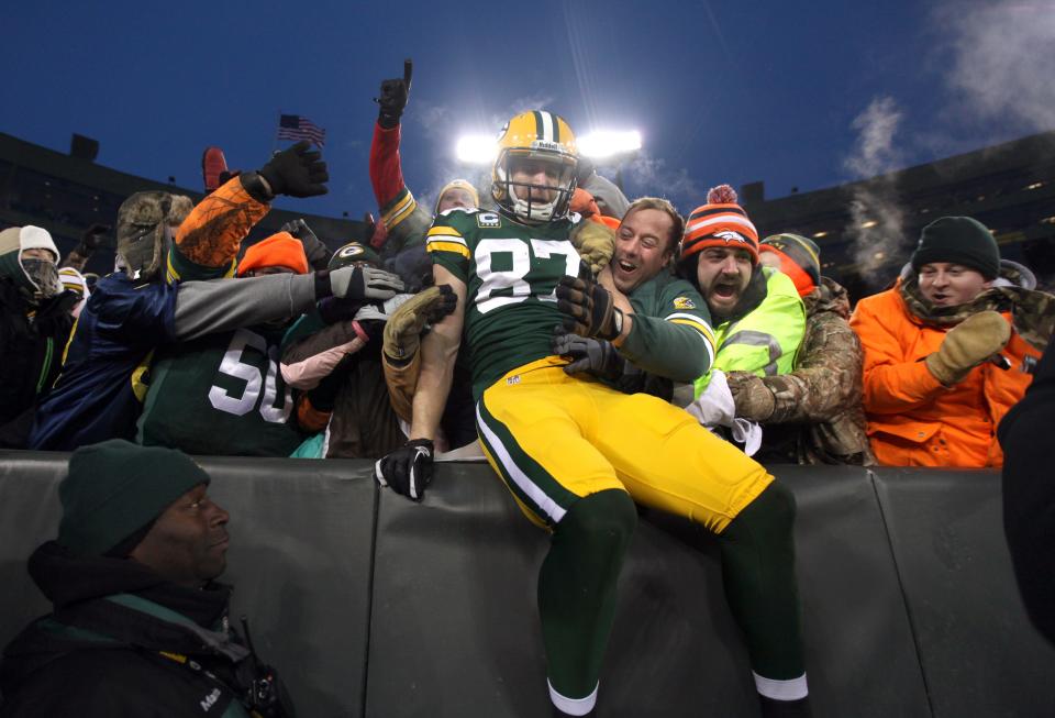 Green Bay Packers wide receiver Jordy Nelson (87) does the Lambeau Leap near Stephen Pfeil (left), of Madison and Sean Sanchez of Denver, after Nelson scored in the second quarter of the 2014 playoff game against San Francisco.