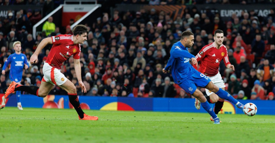 Cyriel Dessers scoring a goal against Harry Maguire.