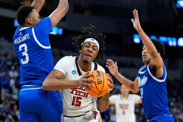 Texas Tech forward JT Toppin (15) gets between Drake forward Cam Manyawu (3) and guard Kael Combs (11) during the second half of the second round of the NCAA college basketball tournament, Saturday, March 22, 2025, in Wichita, Kan. (AP Photo/Charlie Riedel)